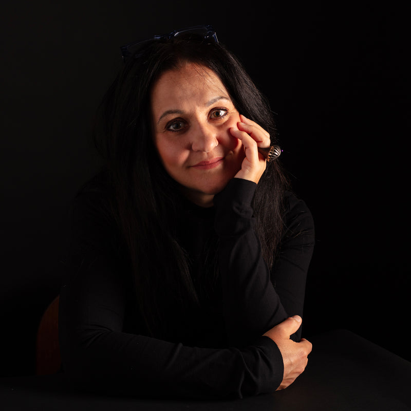 Woman in black clothing against a dark background
